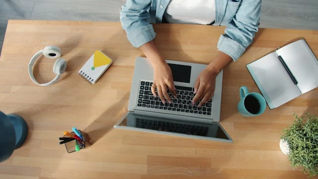 un freelance qui bosse sur son pc vu d'en haut