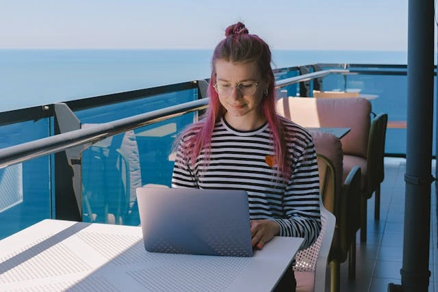une entrepreneuse qui travaille sur un balcon avec vue mer